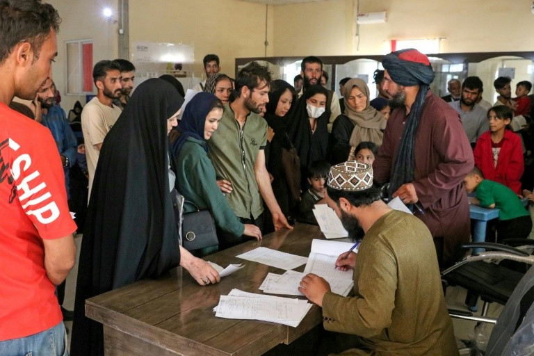 Afghan officials check the documents of refugees after their deportation from Iran, at a registration centre near the Afghanistan-Iran border in Herat province
