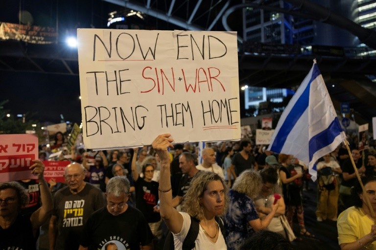 Supporters and relatives of Israelis held hostage by Palestinian militants in Gaza protest outside the Ministry of Defence in Tel Aviv for their release