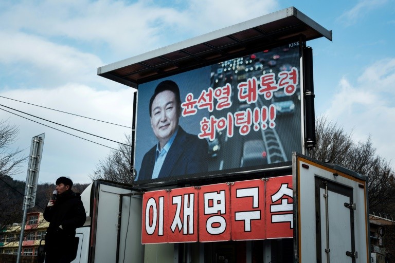 A supporter of impeached South Korean President Yoon Suk Yeol speaks near his residence in Seoul