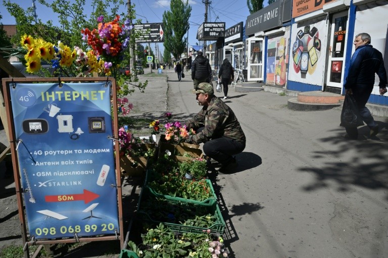 A local resident sells flowers in the town of Dobropillia, Donetsk region, amid the Russian invasion of Ukraine