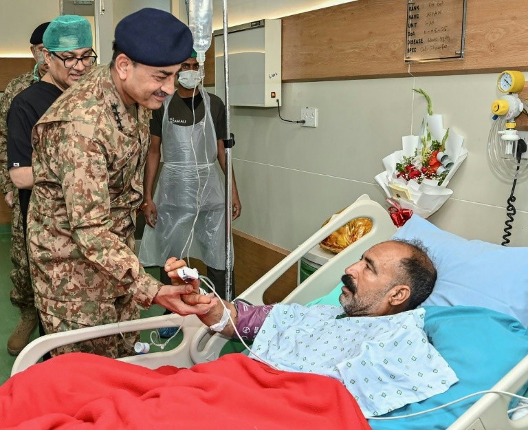 A handout photograph released by the Pakistan military's media wing, Inter Service Public Relations, shows Chief of Army Staff General Syed Asim Munir greeting an iunjured civilian at a hospital in Rawalpindi. Pakistan said 51 people -- 40 civilians and