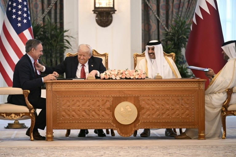 Boeing CEO Kelly Ortberg sits to the left of US President Donald Trump and Qatar's Emir Sheikh Tamim bin Hamad al-Thani (R) during a business deal signing ceremony at the Royal Palace in Doha, on May 14, 2025