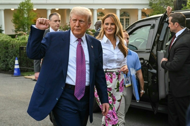 US President Donald Trump (L) raises a fist next to US First Lady Melania Trump during the Congressional Picnic on the South Lawn of the White House in Washington, DC, on June 12, 2025.