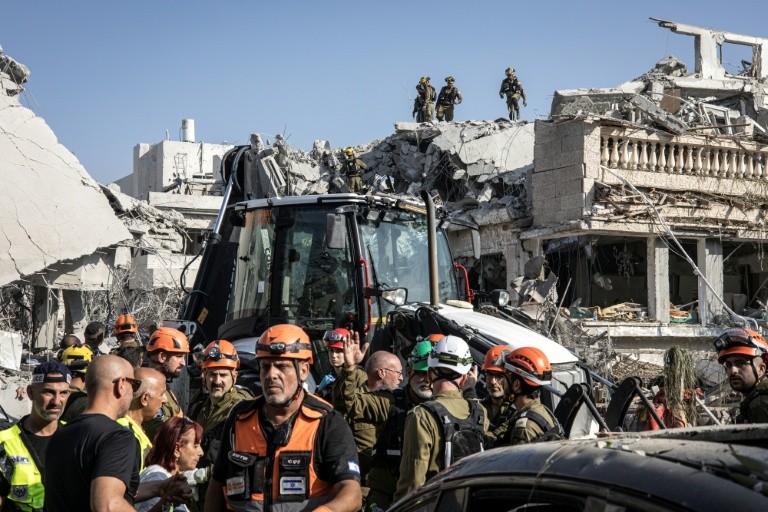 Israeli emergency responders inspect a site hit by a missile fired from Iran south of Tel Aviv