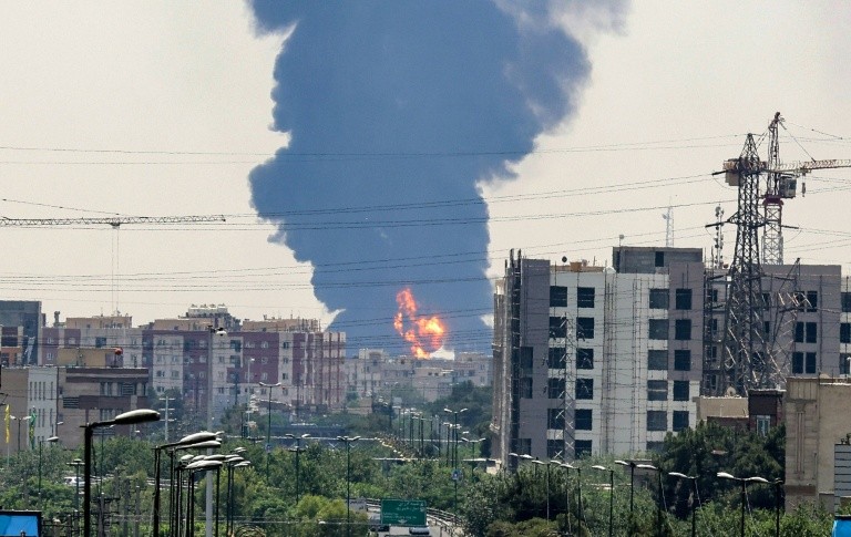 A plume of heavy smoke and fire rise over an oil refinery in southern Tehran, after an overnight Israeli strike