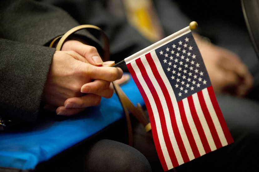 Immigrant holds U.S. flag at naturalization ceremony