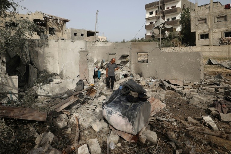 A Palestinian man examines the damage to a house in Deir el-Balah on Tuesday following overnight Israeli strikes
