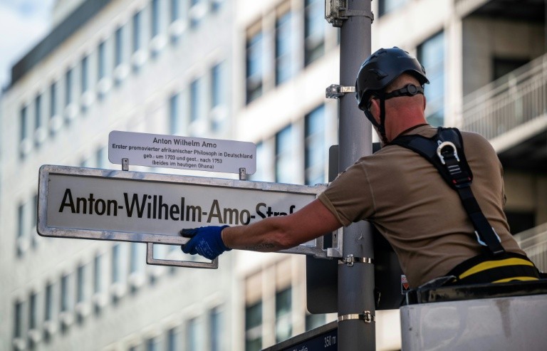 A worker installs a sign with the street's new name, after years of controversy and a last-minute courtroom drama over the old name, 'Moors' Street'