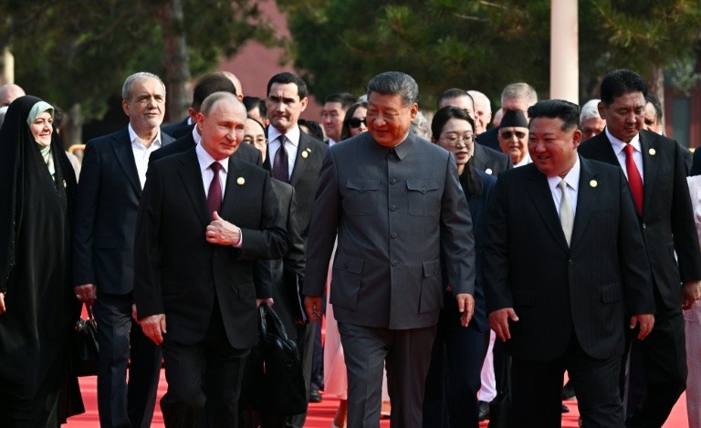 In this pool photograph distributed by the Russian state agency Sputnik, (L-R) Russia's President Vladimir Putin walks with China's President Xi Jinping and North Korea's leader Kim Jong Un before a military parade marking the 80th anniversary of victory