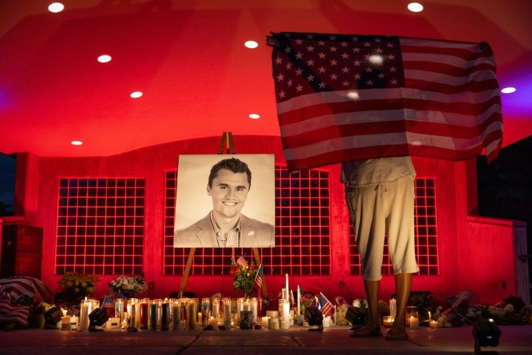 People pay their respects during a candlelight vigil for youth activist and influencer Charlie Kirk at a makeshift memorial at Orem City Center Park in Orem, Utah