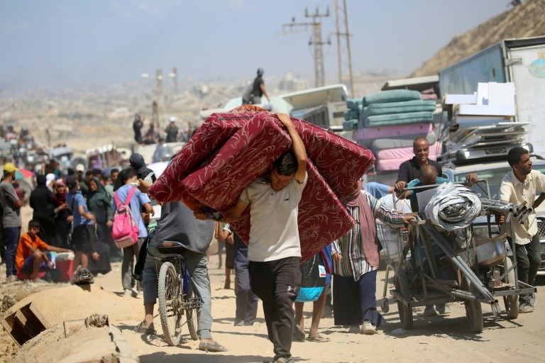 Palestinians from Gaza City move southwards with their belongings, on the coastal road near the Nuseirat refugee camp in the central Gaza Strip, on September 19, 2025. The Israeli military warned on September 19, that it will operate with "unprecedented f