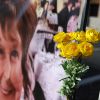 Memorial flowers at a banner for Nancy Guthrie
