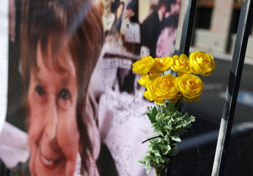Memorial flowers at a banner for Nancy Guthrie